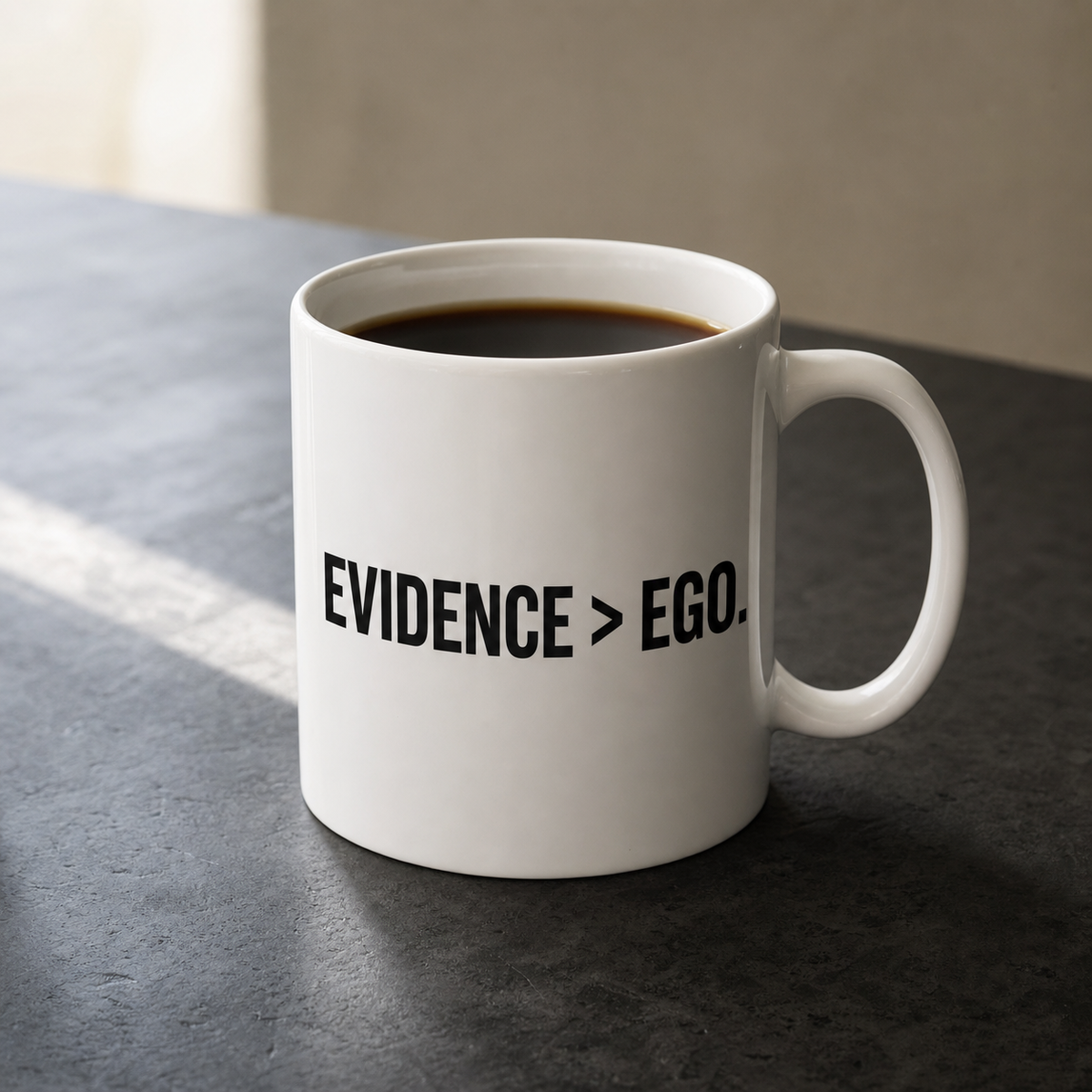 White 11 oz Flowkeeper Mug printed with 'Evidence > Ego.'